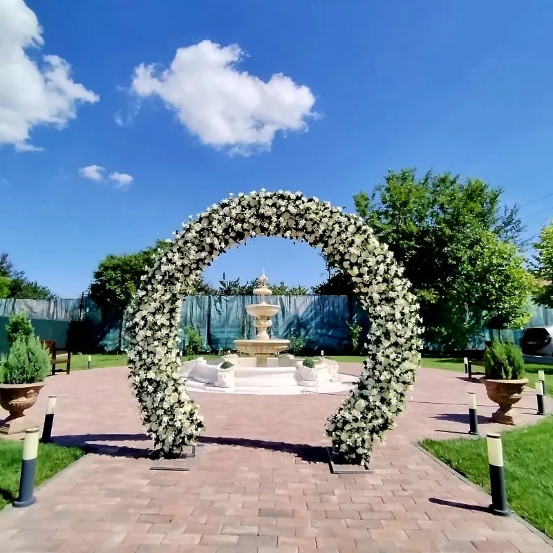 Arcadă florală albă pe aleea din grădina Poiana Verde, pregătită pentru o nuntă