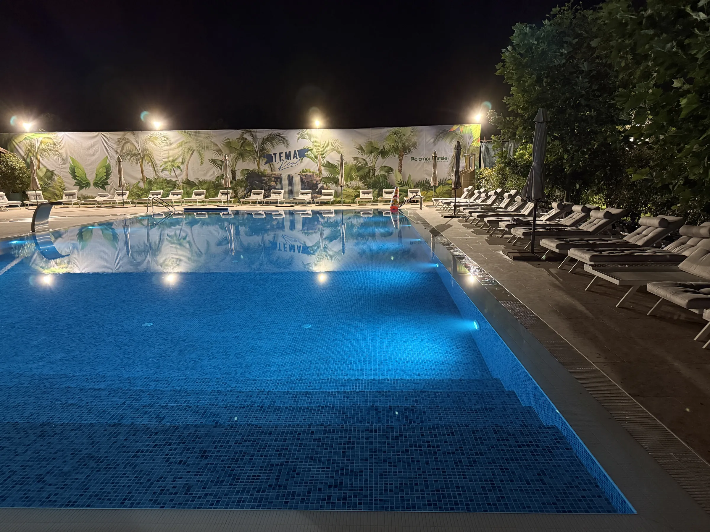 Piscina iluminată noaptea cu ghirlande de lumini, petrecere la Tema Pool Poiana Verde