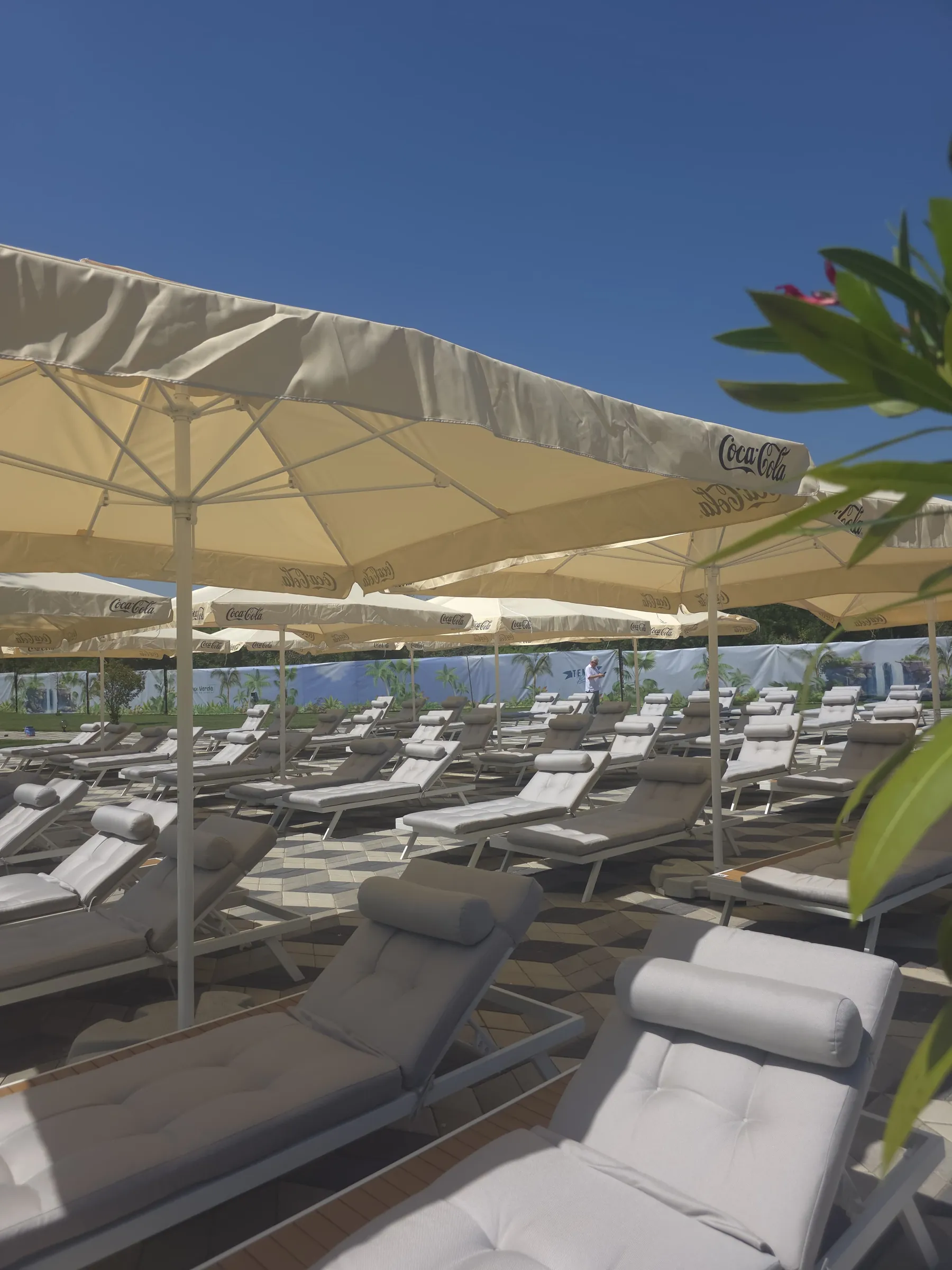 Șezlonguri cu umbrelă la marginea piscinei în lumina serii, Poiana Verde