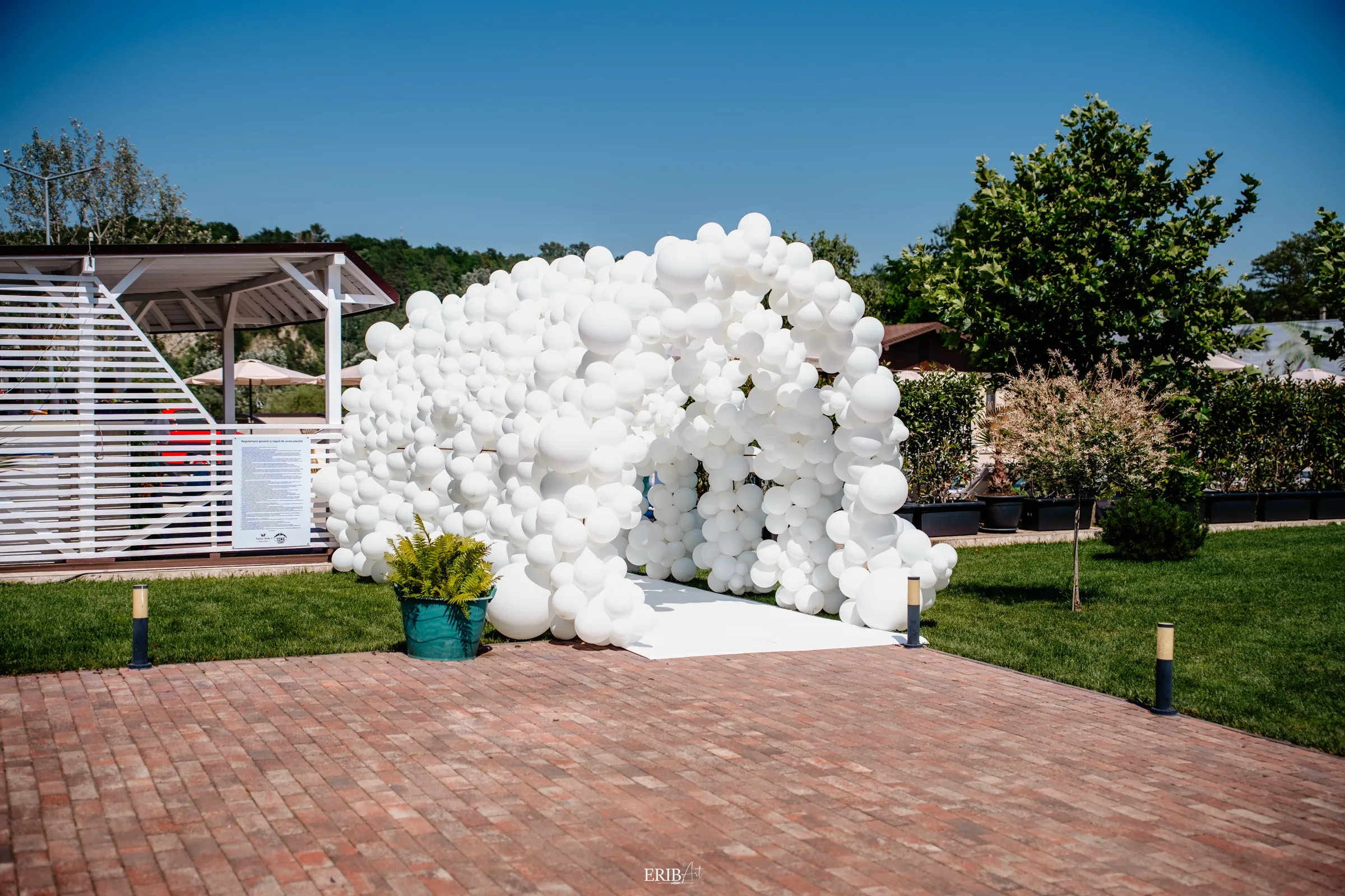 Arcadă de baloane albe la intrarea în evenimentul de la Poiana Verde Garden House